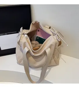Interior view showing the large capacity of a beige canvas tote bag with a tablet and phone