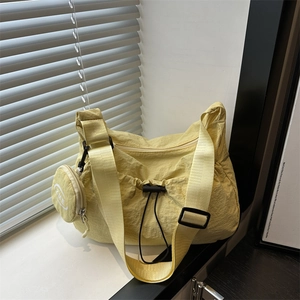 Light yellow nylon crossbody tote bag with round coin purse and wide shoulder strap