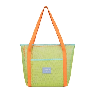 Colorful mesh beach tote bag with neon green body and orange straps on white background