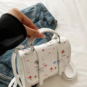 Makrodetail der weißen Modetasche mit Cartoon-Prints und von Hand gehaltenem Griff
