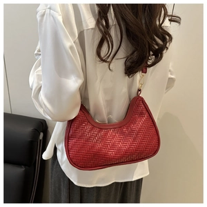 Detail of red woven hobo bag showing V-pattern texture and gold metal hardware hooks