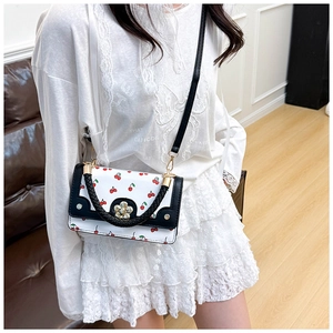 Detail of white cherry print handbag with flower buckle and black woven handle