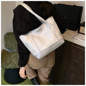Detail of white textured tote bag with Fashion tag worn over the shoulder by model