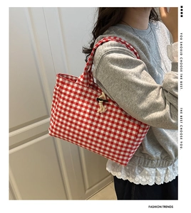 Close-up of red checkered canvas tote bag with a wooden toggle button closure detail