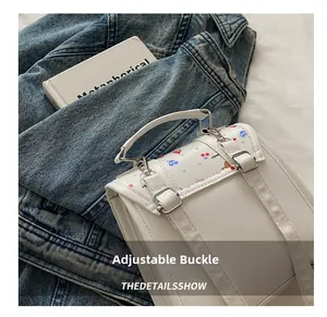 Detaillierte Nahaufnahme der verstellbaren silbernen Metallschnalle an einem weißen Damenrucksack