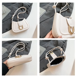 Close-up of cream shoulder bag featuring gold D-ring hardware and interior storage