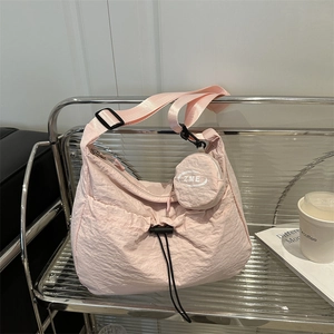 Minimalist light pink tote bag with adjustable strap and small round coin purse charm