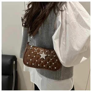 Detail of brown quilted patent leather shoulder bag with large silver star and rhinestones