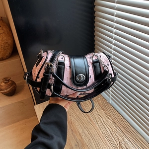 Sac bandoulière bicolore rose et noir avec motifs gaufrés et fermoir rotatif en métal argenté