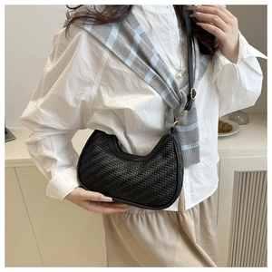 Borsa a mezzaluna intrecciata nera alla moda indossata a spalla da una modella