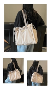 Detail of off-white canvas tote bag featuring brand patch and adjustable side drawstrings
