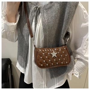 Détail d'un sac bandoulière en cuir verni marron avec strass matelassés et motif d'étoile