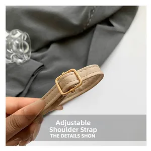 Detail of adjustable beige canvas shoulder strap with polished gold metal buckle for bags