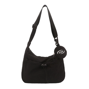 Black crescent tote bag with adjustable strap and detachable round coin purse charm