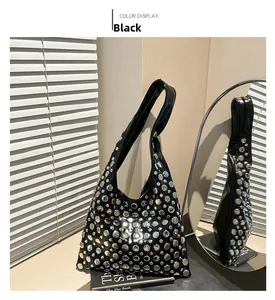 Close-up of black rivet bucket bag with silver studs and wide shoulder strap
