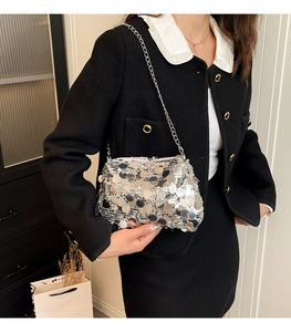 Detail of silver sequin handbag with thin metal chain strap and layered sparkling texture