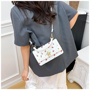 Chic white crossbody bag featuring red cherry prints and golden flower clasp detail