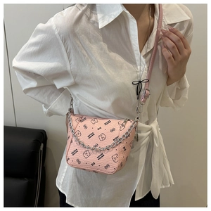 Detail of pink crossbody bucket bag with chain strap and cartoon bear print on leather