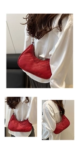 Detail of red woven hobo bag showing handcrafted PU texture and gold zipper closure