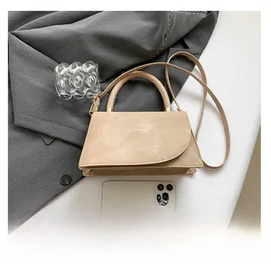 Beige suede small crossbody bag shown with a smartphone for size reference