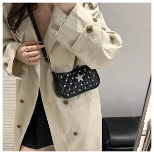Close-up of black quilted crossbody bag with silver star rhinestone and shiny finish
