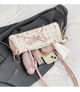 Detail view of large floral shoulder bag showing storage for phone and cosmetics