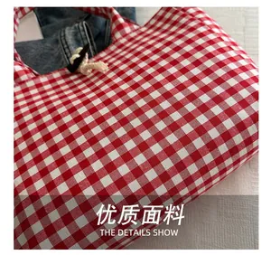 Macro shot of red and white checkered canvas tote bag showing high-density fabric texture