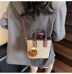 Sac seau rétro en toile avec garniture en cuir marron et breloque peluche sur modèle