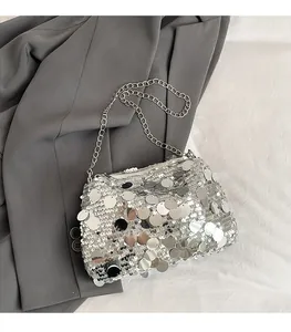 Detailed close-up of shiny silver sequins and metallic chain on small square crossbody bag