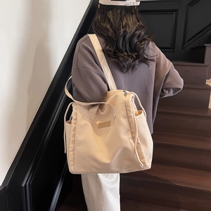 Large beige canvas tote bag with drawstring side detail for women's daily commute