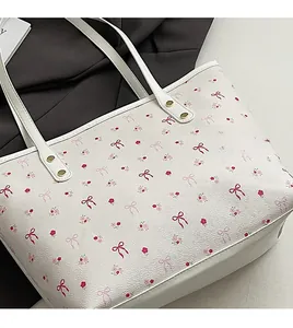 Détail du sac cabas blanc avec motifs floraux roses et imprimés de nœuds sur cuir PU