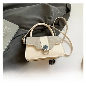 Detailansicht der cremefarbenen Tasche mit Glitzerklappe und Smartphone zum Größenvergleich