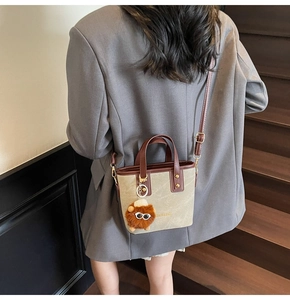 Détail du mini sac seau en toile kaki et cuir avec un porte-clés monstre mignon