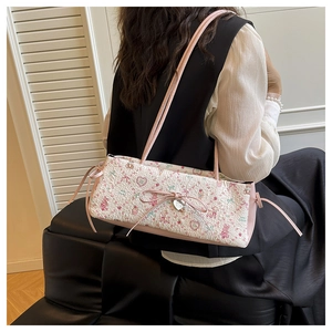 Detail of floral shoulder bag featuring pink heart charms and teddy bear embroidery motifs