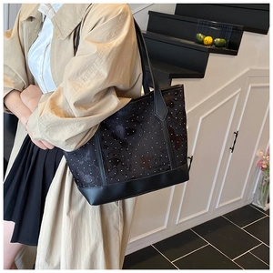 Detail of black polka dot tote bag showing fashion lettering and dual leather straps