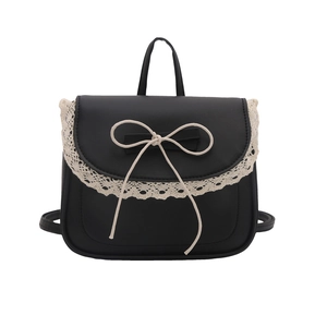 Black PU leather mini backpack with white lace trim and bow accent on white background