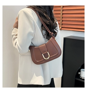 Detail of coffee brown leather crescent shoulder bag with golden U-shaped buckle decoration