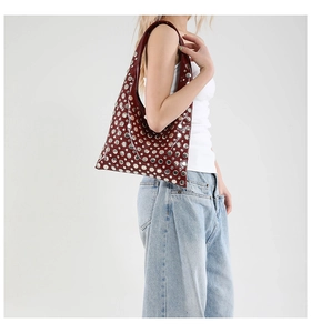 Detailed macro view of wine red patent leather hobo bag with silver metallic studs