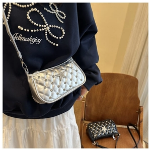 Detail of silver quilted shoulder bag featuring star rhinestone and metallic studs