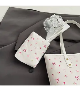 Détail du sac cabas en cuir blanc à fleurs roses avec une petite pochette zippée assortie
