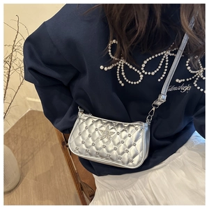 Detail of silver quilted crossbody bag with rhinestone star and metallic studs