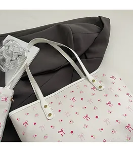 Détail de la bandoulière de cabas blanc avec motif floral rose et rivets dorés