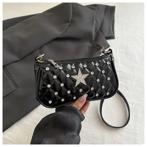Detail of black quilted crossbody bag with rhinestone star and silver stud accents