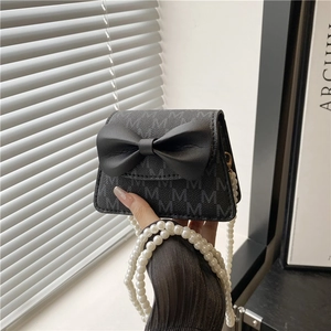 Mini black leather crossbody bag with a 3D bow and pearl chain strap for women