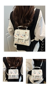Details eines weißen Mini-Rucksacks mit niedlichen Mustern, getragen als Umhängetasche