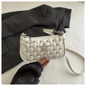 Detail of white quilted handbag featuring silver rhinestone star and stud embellishments