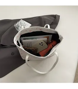 Intérieur spacieux du cabas blanc à nœuds rouges avec livres et effets personnels
