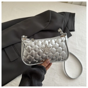 Detail of silver metallic quilted shoulder bag with rhinestone star and Y2K stitching