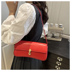 Detail of red leather shoulder bag with vintage gold U-shaped rotating lock buckle