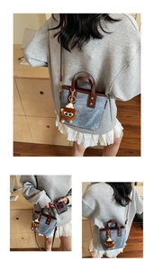 Detail of denim bucket bag with brown leather trim and cute lion plush charm